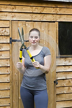 Young woman with garden pruner in garden