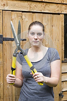 Young woman with garden pruner in garden