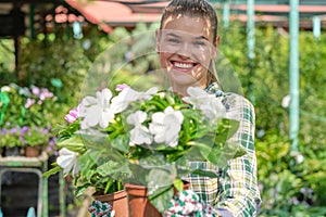 Young woman gardening in greenhouse.She selecting flowers