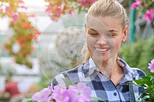 Young woman gardening in greenhouse.She selecting flowers