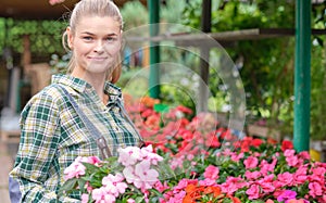 Young woman gardening in greenhouse.She selecting flowers