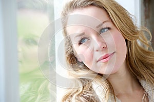 Young woman gazing out window photo