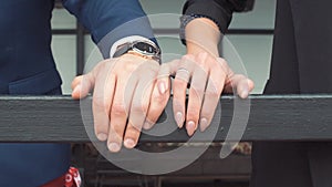 Young woman gently touches male hand. Romantic couple holding hands