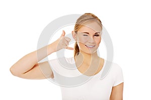 Young woman gesturing call me sign