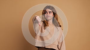 Young woman gesturing disagreement with thumb down