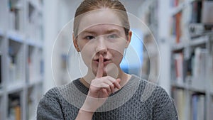Young Woman Gesturing Silence, Finger on Lips, Indoor