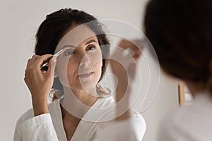 Young woman get ready pinch eyebrows in bathroom