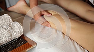 Young woman gets a foot massage in the spa salon. close-up of candles