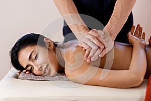 A young woman gets a massage procedure. Masseur makes back massage.