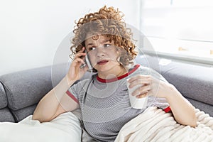 Young woman getting bad news by phone. unhappy woman talking on mobile phone looking down. Crying depressed girl holds phone