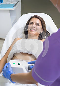 Young woman getting cryolipolyse treatment in cosmetic ca