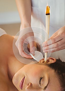 Young woman getting an ear candling treatment