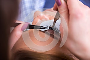 The young woman getting eyelash extension
