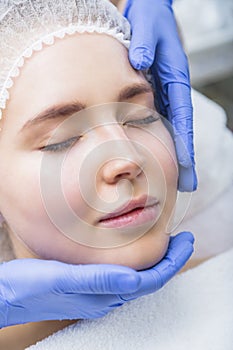 Young woman getting face massage at beauty salon