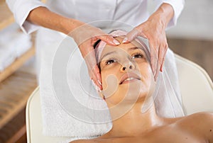 Young woman getting facial massage in salon