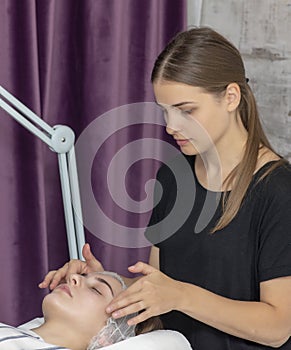Young woman getting facial massage at spa salon