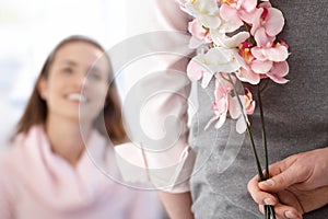 Young woman getting flowers from boyfriend