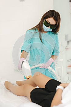 Young woman getting laser treatment on leg at spa. Laser epilation and cosmetology