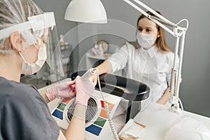 Young woman getting manicure in beauty salon