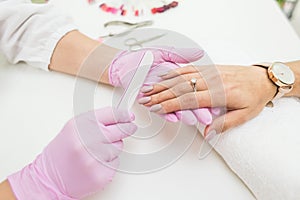 Young woman getting manicure in beauty salon. Close-up