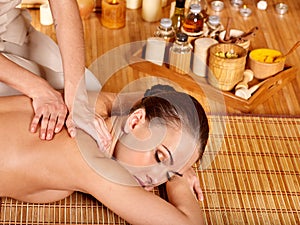 Young woman getting massage in bamboo spa