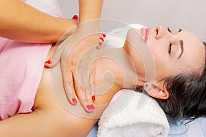 Young woman getting a massage at the spa. A woman enjoys a relaxing back massage in a beauty spa. Body care, skin care