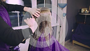 Young woman getting new haircut by hairdresser at parlor or home.