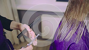 Young woman getting new haircut by hairdresser at parlor or home.