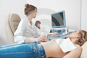 Young woman getting ultrasound scanning examination at the hospi