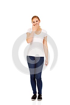 Young woman giggles covering her mouth with hand