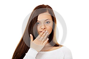 Young woman giggles covering her mouth with hand