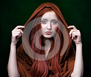 Young woman with ginger hair and scarf on green background