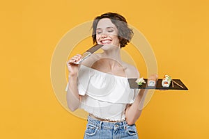 Young woman girl hold in hand choice between chocolate bar makizushi sushi roll served on black plate traditional