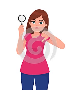 Young woman or girl holding a magnifying glass and making thumbs down gesture sign. Person showing magnifier lens.