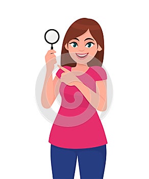 Young woman or girl holding a magnifying glass and pointing index finger. Person showing magnifier lens in hand. Female character.