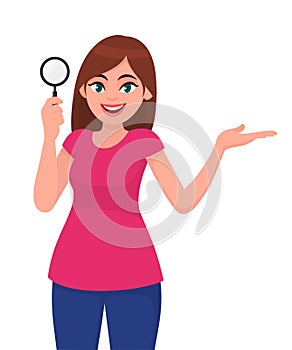 Young woman or girl holding a magnifying glass and pointing or presenting hand gesture to copy space. Person showing magnifier.