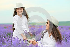 Young woman and girl are in the lavender field, beautiful summer landscape with red poppy flowers