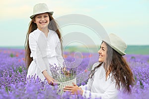 Young woman and girl are in the lavender field, beautiful summer landscape with red poppy flowers