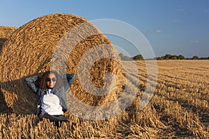 Young Woman Girl Teenager Leaning Against Hay Bale in Field at Sunset