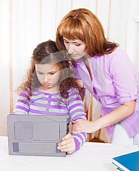 Young woman with girl using tablet computer