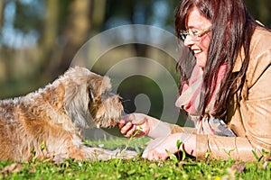 Young woman gives her dog a treat