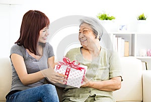 Young woman giving present to grandmother