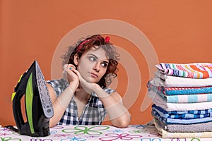 A young woman glances at a folded pile of ironed and fragrant towels.