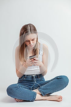 Young woman is glaring at the cell phone.