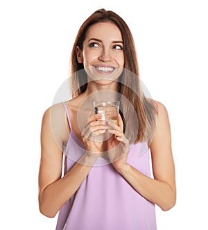 Young woman with glass of lemon water on background