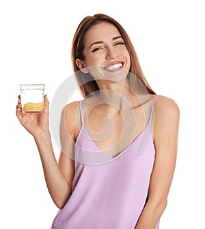 Young woman with glass of lemon water on background