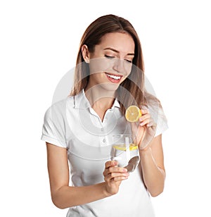 Young woman with glass of lemon water on background