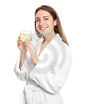 Young woman with glass of lemon water on background