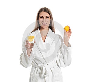 Young woman with glass of lemon water on background