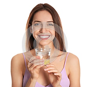 Young woman with glass of lemon water on background